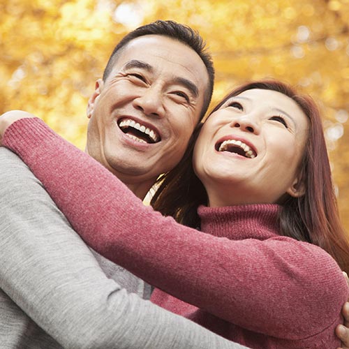 Smiling couple laughing in autumn woods